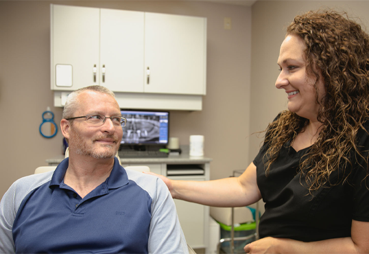 male patient with a female staff member talking.