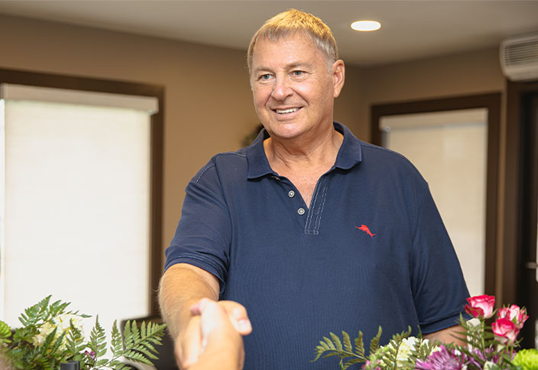 middle aged man shaking hands with staff member at Premier Oral Surgery.